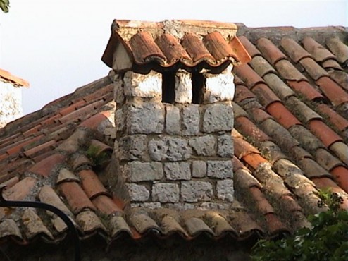 Close up of brick chimney on a tiled roof in San Paul de Vence